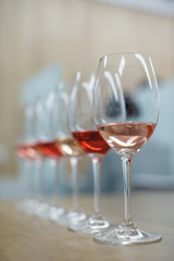 Row of glasses with white and rose wines prepared for degustation - vertical shot