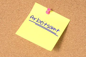 Eine Pinnwand mit dem Zettel für einen Termin beim Arbeitsamt