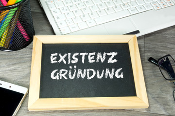 Ein Büro und eine Kreidetafel mit dem Wort Existenzgründung