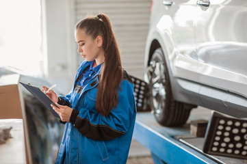 Young beautiful girl at an auto mechanic at work