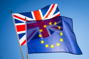 EU European Union flag flying with UK United Kingdom flag together in a spirit of cooperation in bright blue sky