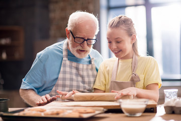 grandfather and granddaughter making dough