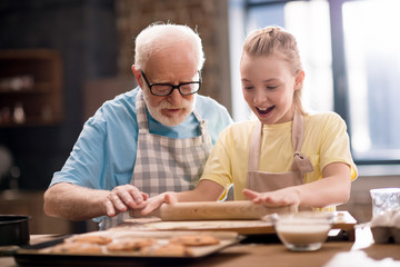 grandfather and granddaughter making dough