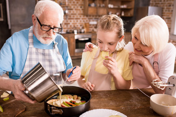 grandparents and girl cooking together