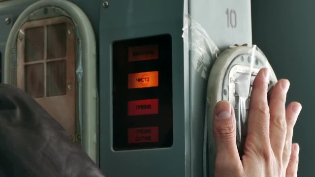 Radiometer contamination of hands. In the Chernobyl zone, a man leans his hand against a special apparatus to check whether they are contaminated. 2017, Chernobyl, Ukraine