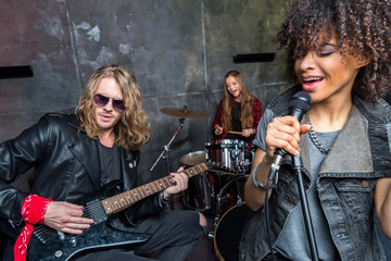 Obraz premium young rock band rehearsing in musical studio, band on stage concept