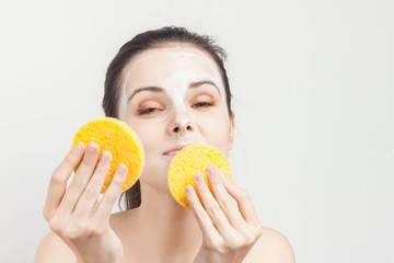 beautiful woman in a light mask and with yellow sponges