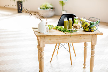 Table full of healthy green food and smoothies at the beautiful interior with greenery