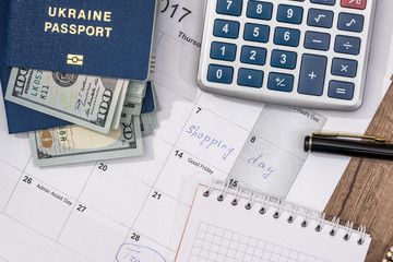 calendar, passport, us dollar, calculator and pen on desk.