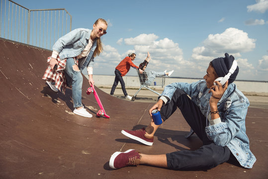 teenagers having fun in skateboard park, hipster students concept