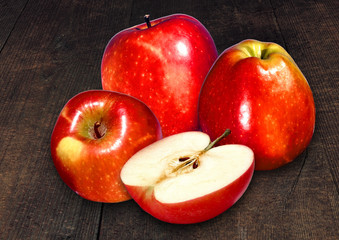 Red apple and slice on a wood surface background