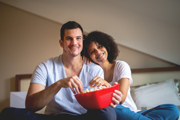 Couple enjoying sharing time at home with movie and popcorn.