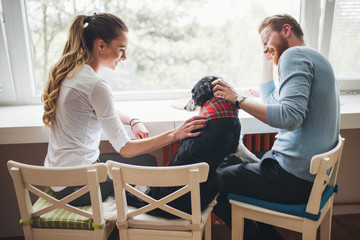 Beautiful couple relaxing at home and loving their dog