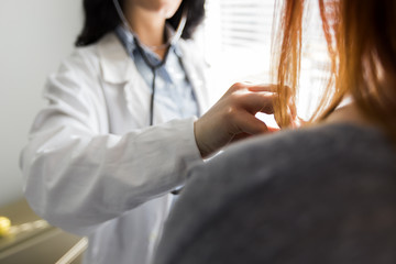 Medical female doctor and patient on white background with the stethoscope, blood pressure measuring.