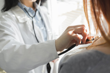 Obraz premium Medical female doctor and patient on white background with the stethoscope, blood pressure measuring.