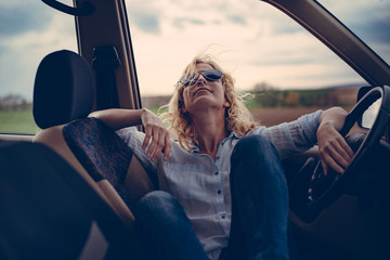 Woman on vacation, resting in car