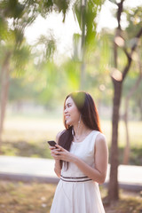 woman using earphone and smartphone at park