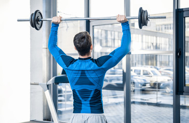 Fototapeta premium Handsome young man workout with barbell at gym