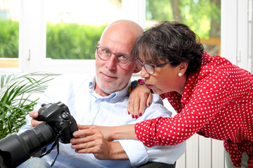 Fototapeta premium Senior couple looking at pictures on the camera screen