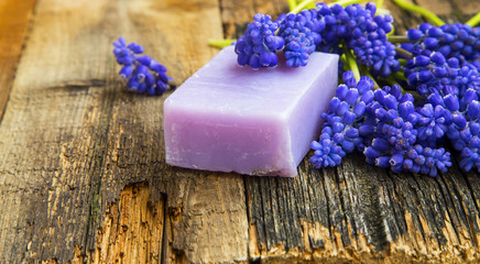 Obraz na płótnie Canvas Natural handmade soap with purple flowers on wooden background
