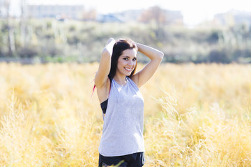 Young beautiful sportive woman raising arms.