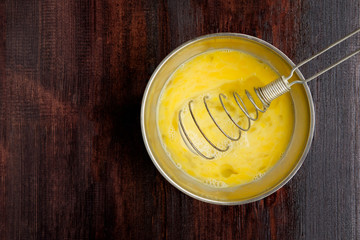 mixing eggs in steel bowl with whisk. Copy spase
