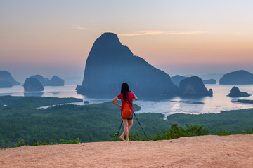 Photographer woman standing outdoor photography amidst the beautiful scenery of mountain view and...