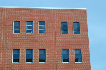 Fototapeta na wymiar red brick wall and windows on blue sky
