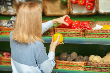 Beautiful woman buying vegetables in market