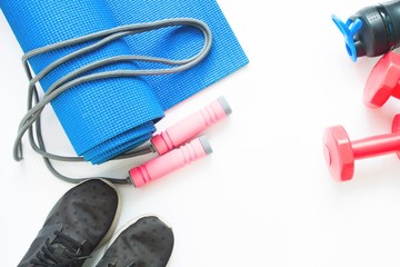 Flat lay of female sport and yoga equipments on white background with copy space