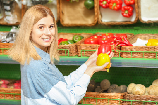 Beautiful woman buying vegetables in market