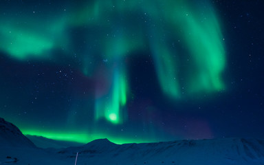 The polar Northern aurora borealis lights in Norway Svalbard in the mountains