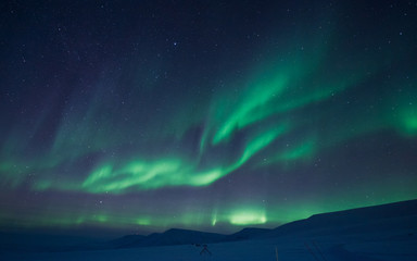 Naklejka na ściany i meble The polar Northern aurora borealis lights in Norway Svalbard in the mountains