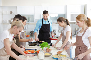 Male chef and group of people at cooking classes