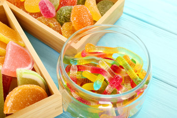 Composition of tasty jelly candies on wooden background, closeup