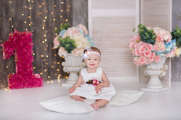 Cute baby girl 1-2 year old sitting on floor with pink balloons in room over white. Isolated. Birthday party. Celebration. Happy birthday baby, Little girl with group ball. Play room.