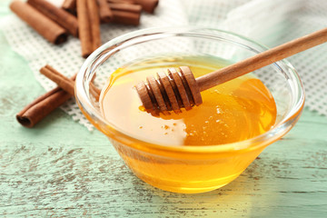 Cinnamon and honey in glass bowl on table, closeup
