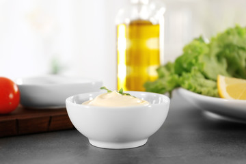 Delicious mayonnaise in bowl on kitchen table