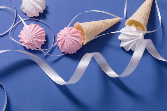 Meringue pie in a waffle horn on a blue background