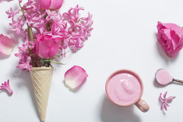 Flowers in a waffle cone with yogurt on white background
