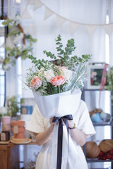 soft focus a girl with white dress holding beautiful big bouquet hidden her face