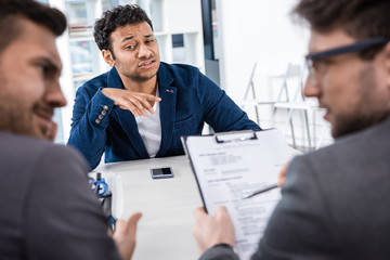 grimace businessman sitting at table during job interview, business concept