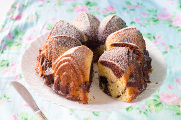 Round sponge cake on a white plate, in the style of a shebby. Selective focus