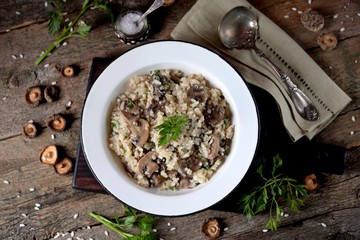 Risotto with mushrooms on an old wooden background. Rustic style.