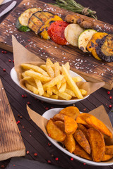 Fried potatoes in a rural and French fries, vegetables on coals