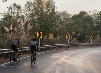 Asian men are cycling road bike morning uphill on the road