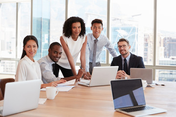 Portrait Of Businesspeople Meeting Around Table In Office