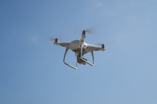 Flying drone with blue sky background controlled by professional photographer