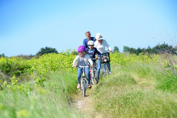 Fototapeta premium Happy family riding bikes on week-end in countryside