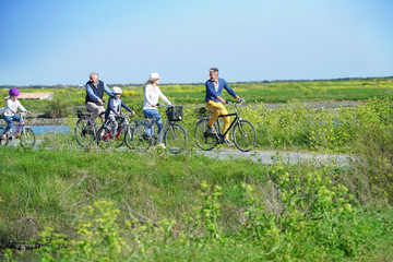 Family riding bikes together on country road